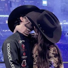 a man in a cowboy hat kissing a woman's face on the set of tonight show