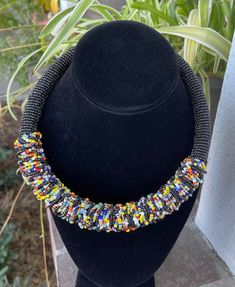 The Akuleau beaded choker style necklace is a choker style with solid color beads and colorful embellishment. Very lightweight and colorful. Ladies of Baskets and Beads in Kenya modeling many of the necklaces. Note: beaded embellishment may be slightly different than pictured.