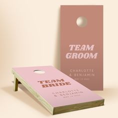 a pink and white cornhole game with the words team groom on it next to a wooden board