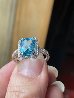 This lovely ring features a 3.56 carat Swiss Blue Topaz which is IF clarity. The Topaz boasts a Checkerboard Cut which aids in it's sparkle and beauty! It measures 10x8mm, and is surrounded by Natural White Topaz. The setting is Sterling Silver which has a Rhodium coating, keeping it from tarnishing.  This ring is a finger size 8. It will arrive in a nice little gift box and ready for a bow!  Thank you for looking! Spessartite Garnet, Purple Pearl, Swiss Blue Topaz, Lovely Ring, Blue Band, White Topaz, Rings Statement, Blue Topaz, Beautiful Earrings