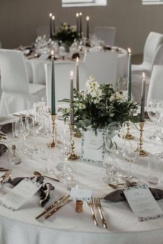 the table is set with white linens and silverware