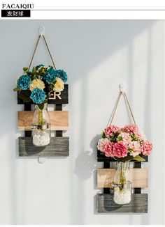 two vases with flowers are hanging on the wall, one is made out of wood