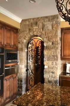 a kitchen with granite counter tops and wooden cabinets, an iron gate leading to the oven