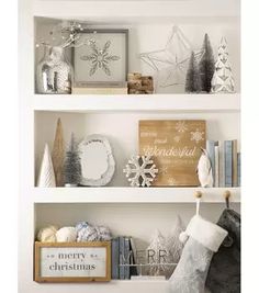 christmas decorations are displayed on the shelves in this white and silver home decorated with snowflakes