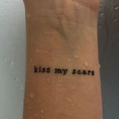 a wrist tattoo with the words kiss my scars written on it's left arm