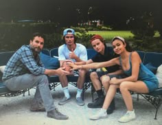 a group of people sitting on top of a blue bench next to eachother