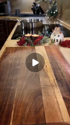 a wooden cutting board sitting on top of a kitchen counter next to a christmas tree