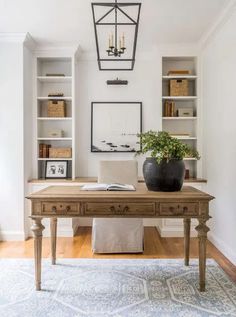 a desk with a potted plant on top of it in front of bookshelves