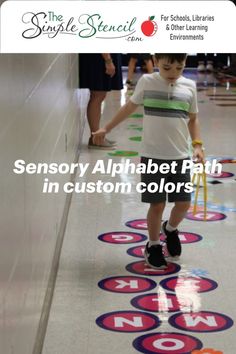 a young boy is walking on the floor in front of an advertisement for children's learning