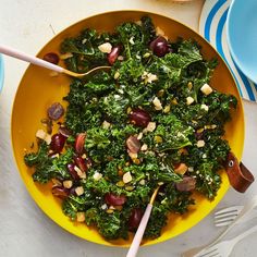 a yellow bowl filled with greens and olives