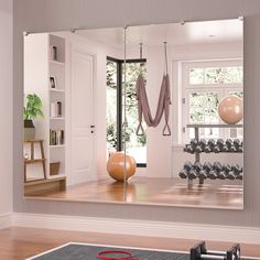 an exercise room is reflected in the mirror on the wall, and there's a gym equipment set up behind it