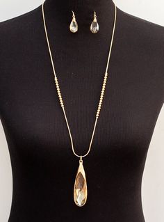 This Gold Chain And Champagne Crystal Necklace And Earring Set is beautiful Novelty gold tone chain leads to champagne crystal teardrop pendant Material: Faux crystal stone, gold tone chain Include champagne crystal tear drop earrings Lobster closure with 3" extension Necklace length from neck to bottom 12" plus 3" chain extension Gold Teardrop Pendant Jewelry For Party, Party Jewelry With Delicate Chain And Teardrop Pendant, Party Jewelry With Delicate Teardrop Pendant, Party Teardrop Pendant With Delicate Chain, Delicate Teardrop Pendant For Party, Gold Teardrop Pendant Chain Necklace, Gold Metal Drop Necklace, Teardrop Pendant Metal Jewelry For Parties, Teardrop Pendant Party Jewelry