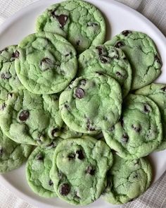 a white plate filled with green chocolate chip cookies