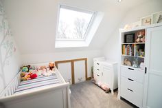 a baby's room with a crib, dresser and bookcase in it