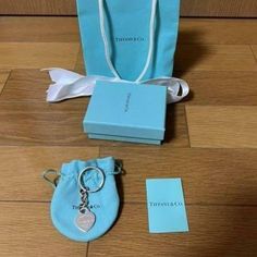 a blue bag with a heart shaped keychain sitting next to it's packaging