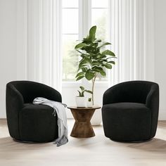 two black chairs sitting next to each other on top of a hard wood floor near a potted plant