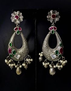 Stunning German silver Indian Chandbali earrings, embellished with sparkly cut CZ stones. Eye catching asymmetric design with a scrolling floral pattern on one half of the earring, and the CZ stones on the other half! Beautiful dangly pearls and silver color stamped balls move when you move, in a very alluring way! Pretty ear stud in shape of flower. Grey finish, polished to a lovely soft lustre. Lots of intricate detail! Excellent quality and craftsmanship! Length 3 3/4 in Width 2 in Weight 14 Elegant Oxidized Chandbali Jhumkas, Silver Chandbali Chandelier Earrings With Oxidized Finish, Festive Oxidized Chandbali Chandelier Earrings, Bohemian Oxidized Chandbali Jhumkas, Sterling Silver Chandbali Danglers With Oxidized Finish, Earring Indian, Chandbali Earrings, Black Beaded Jewelry, Ear Stud