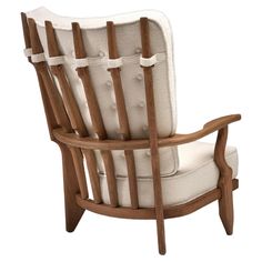 a wooden chair with white upholstered fabric on the back and armrests