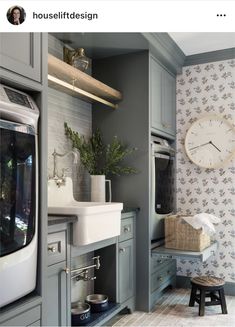 an image of a kitchen setting with grey cabinets and wall paper on the back walls