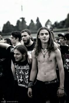 a group of young men standing next to each other in front of a crowd at a music festival