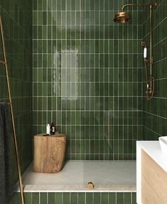 a green tiled bathroom with a wooden standup shower head and hand held faucet