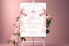 a welcome sign with pink flowers and greenery in front of a pink backdrop that says, welcome to all's graduation party we are so proud