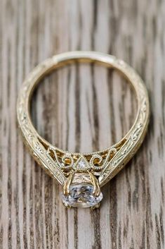 an antique style engagement ring on a wooden table