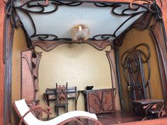 an old fashioned mirror in the corner of a room with antique furniture and decor on display