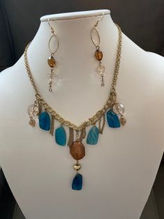 "Blue, brown, gold themed chain and bead necklace and earrings made from vintage materials.  Earrings have French hooks and necklace had lobster claw clasp.  Kept in a smoke free environment. Necklace measures 25\" long.  Earrings measure 3\"." Bohemian Long Gold Chain Necklace, Elegant Brown Metal Beaded Necklace, Vintage Brown Dangle Jewelry, Bohemian Gold Chain Necklace, Bohemian Brown Czech Glass Jewelry, Brown Metal Dangle Necklaces, Bohemian Chain Necklace With Dangling Beads For Gift, Metal Long Necklace With Dangling Beads, Bohemian Dangle Beaded Chain Necklace