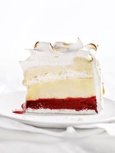 a piece of cake sitting on top of a white plate with red and yellow frosting