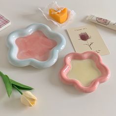 three small dishes with flowers on the table