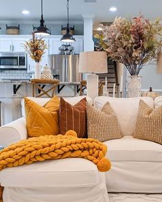 a living room filled with furniture and lots of pillows on top of it's couches