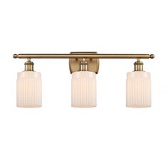 three light bathroom fixture in an antique brass finish with frosted glass shades and gold accents