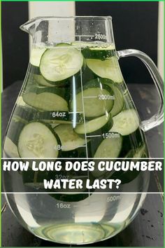 a pitcher filled with cucumbers sitting on top of a table next to a measuring cup