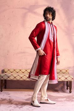 SHRESTHA BY VASTRAMAY Men's Red Silk Blend Machine Embroidered Kurta Pyjama With Silk Dupatta Set Elevate your ethnic wear collection with this luxurious red kurta pyjama set. Features machine embroidery on the neckline, a mandarin collar, and a comfortable fit. Paired with a cream pyjama and silk dupatta. Key Features Red silk blend fabric Machine embroidered neckline Mandarin collar Long sleeves Side slits Pockets (on kurta) Cream colored pyjama with elasticated waistband Silk dupatta Specific Traditional Red Bandhgala For Transitional Season, Traditional Red Bandhgala With Long Sleeves, Traditional Red Ceremonial Sherwani, Traditional Red Long Sleeve Bandhgala, Red Traditional Long Sleeve Bandhgala, Red Long Sleeve Traditional Bandhgala, Designer Red Kurta With Embroidered Border, Red Sherwani With Chikankari Embroidery Long Sleeve, Red Sherwani With Traditional Patterns For Festivals