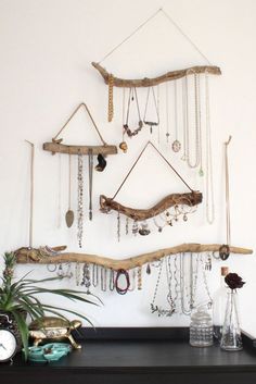 there is a wall hanging made out of branches and jewelry on the shelf next to it