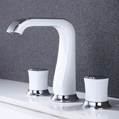 two white faucets sitting next to each other on top of a bathroom counter