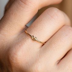 The most precious way to symbolize a close knit bond, the Solid Gold Simple Knot Ring is a piece that's subtle, sleek, and meaningful, all wrapped up in a solid gold package. Family Gold is a Local Eclectic exclusive. 10k solid yellow gold Height 3.5 mm Band width 1 mm Gold Knot Ring, Black Spinel Ring, Friendship Ring, Local Eclectic, Love Knot Ring, Knot Tie, Spinel Ring, Hobbit Hole, Friendship Rings