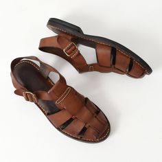 Vintage Cole Haan brown leather fisherman sandals. Adjustable brass buckle. Leather insole. Rubber outsole. Made in Brazil.  Size 10  Note: These seem to run about a half size smaller. Comparing the measurements below with a pair of shoes you own is recommended for sizing accuracy. Good condition with some discoloration/patina to the leather straps and minor surface wear/cracking to the leather insole. The insole has begun to separate from the outsole in a couple of areas which will likely require a visit to the cobbler to have them re-glued at some point down the line. Overall, a classic high quality sandal with lots of life left. Freshly cleaned and leather conditioned.  11" outsole length 10.25" insole length  3.75" outsole width .75" heel Brown Closed Toe T-strap Sandals, Vintage Leather T-strap Sandals, Vintage Closed Toe Sandals With Leather Footbed, Vintage Leather T-strap Sandals With Open Toe, Vintage Leather T-strap Open Toe Sandals, Brown T-strap Sandals With Leather Footbed And Closed Toe, Brown Closed Toe T-strap Sandals With Leather Footbed, Vintage T-strap Sandals For Summer, Vintage Brown Sandals With Leather Footbed