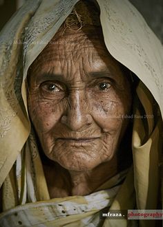 an old woman with wrinkles and scarves on her head is looking at the camera