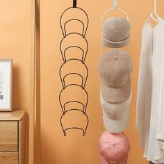 there is a hat rack with hats on it next to a wall mounted coat rack