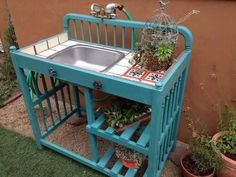 an outdoor sink with plants growing out of it and on top of a wooden stand