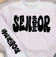 a white shirt with the word senior on it next to a pair of scissors and other items