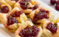 small pastries with cranberry sauce on a white plate