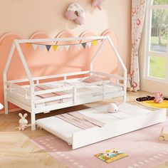 a child's bedroom with pink walls and white bed frame, wooden flooring