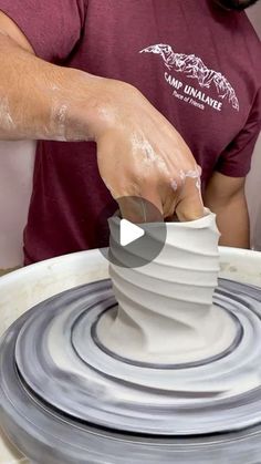 a man working on a pottery wheel with his hands