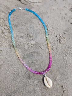 Our Tropical Shell Chokers Indulge in the essence of paradise with every wear! This Shell Choker brings a touch of tropical beauty to any outfit, making you feel like you're lounging on a remote island. Handcrafted with genuine shells, each choker is unique and radiates a luxurious, beachy vibe. Elevate your style and transport yourself to a beach getaway every time you put on this statement piece! Strung on durable jewelry cord, this Shell choker is adorned with rainbow faceted glass beads and a cowrie shell as the focal point and a sterling silver closure. These necklaces can be worn alone or stacked for a laid-back, tropical beachy feel. Dimensions: measuring 16 inches around (rainbow variations may vary) Add this one-of-a-kind necklace to your cart today and bring a touch of the ocean Beachy Shell Necklace For Festival Season, Summer Festival Shell Strand Necklace, Beachy Shell Necklace For Festivals, Beachy Shell Necklaces For Festivals, Hippie Choker Jewelry For The Beach, Bohemian Strand Necklaces For Beach Party, Adjustable Bohemian Necklaces For Beach Party, Beach Shell Necklaces With Colorful Beads, Colorful Beaded Shell Necklaces For Vacation