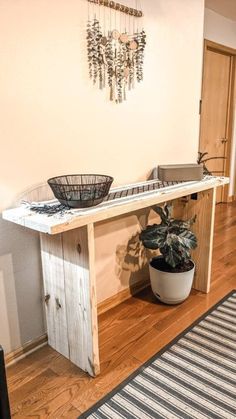 a potted plant sitting on top of a wooden table in a living room next to a rug