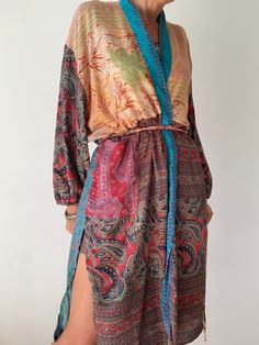 "This is one of a kind patchwork, upcycled silk robe Made free size with wrap tie closing and short sleeves  Easy and fun to wear around the house or outside as a urban boho style,  flowy kardigan with jeans and tshirt  It is very comfy and feels soft and light  the material is colourful indian saree silk made into this unique stylish over all MEAESURE free size length 38\" MATERIAL *saree silk, no lining More ideas at  https://www.etsy.com/shop/AltheaStores? CARE INSTRUCTIONS  * Wash in warm wa Patchwork Long Sleeve Kimono For The Beach, Long Sleeve Patchwork Kimono For The Beach, Bohemian Kimono With Tie Waist And Kimono Sleeves, Bohemian Kaftan With Tie Waist And Kimono Sleeves, Bohemian Long Sleeve Patchwork Kimono, Beach Kimono With Patchwork Sleeves, Bohemian Festival Kimono With Tie Waist, Fall Patchwork Kimono With Kimono Sleeves, Bohemian Wrap Kimono With Tie Waist