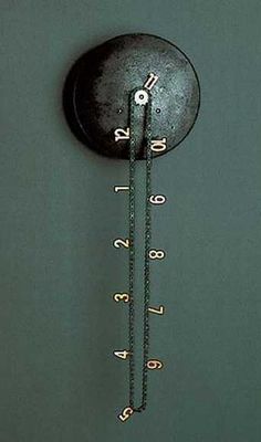 an analog clock hanging from the side of a wall with numbers on it's face